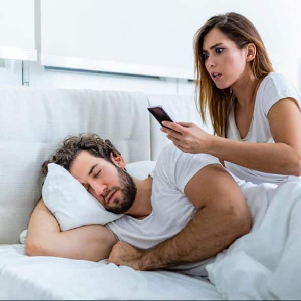 Woman checking man’s phone