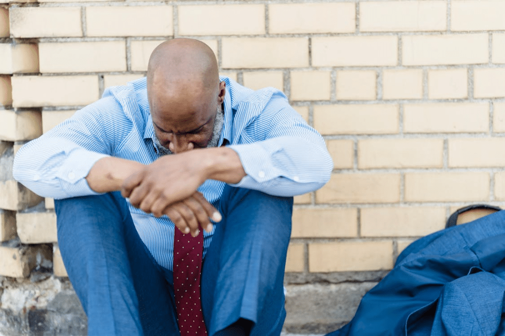 Man sitting on the curb looking down alone