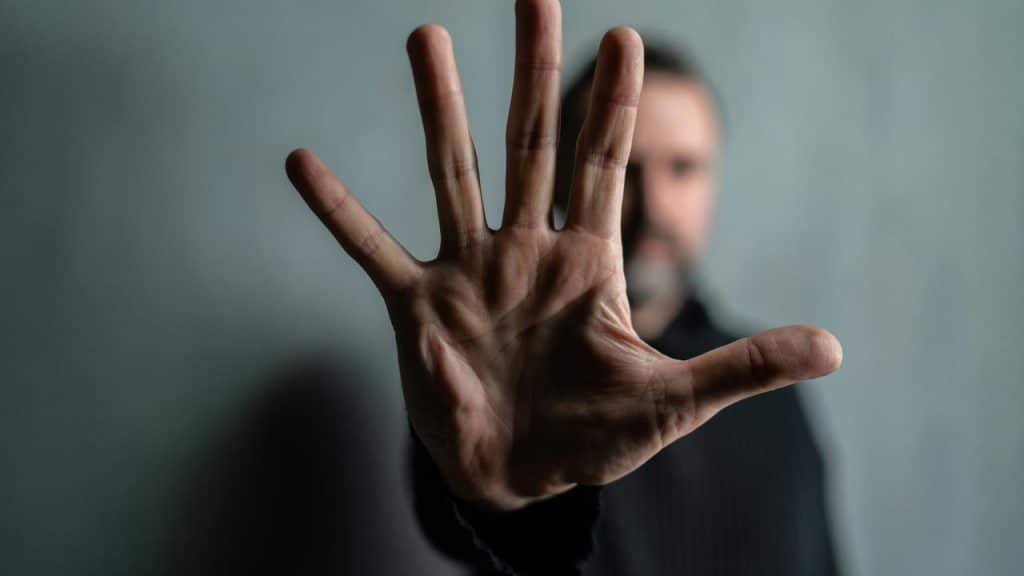 A man holding up his hand toward the camera.