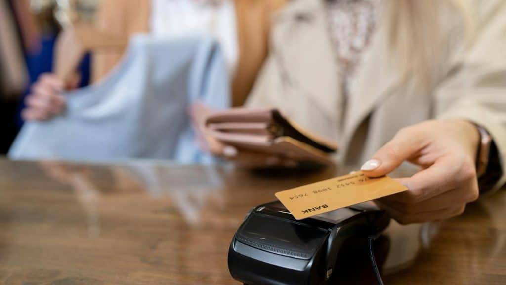 A person paying for clothes with a credit card at a store.