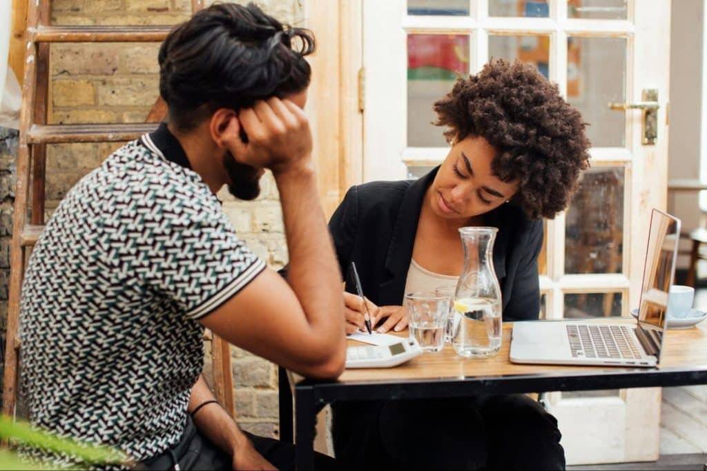 A man looking at the woman working
