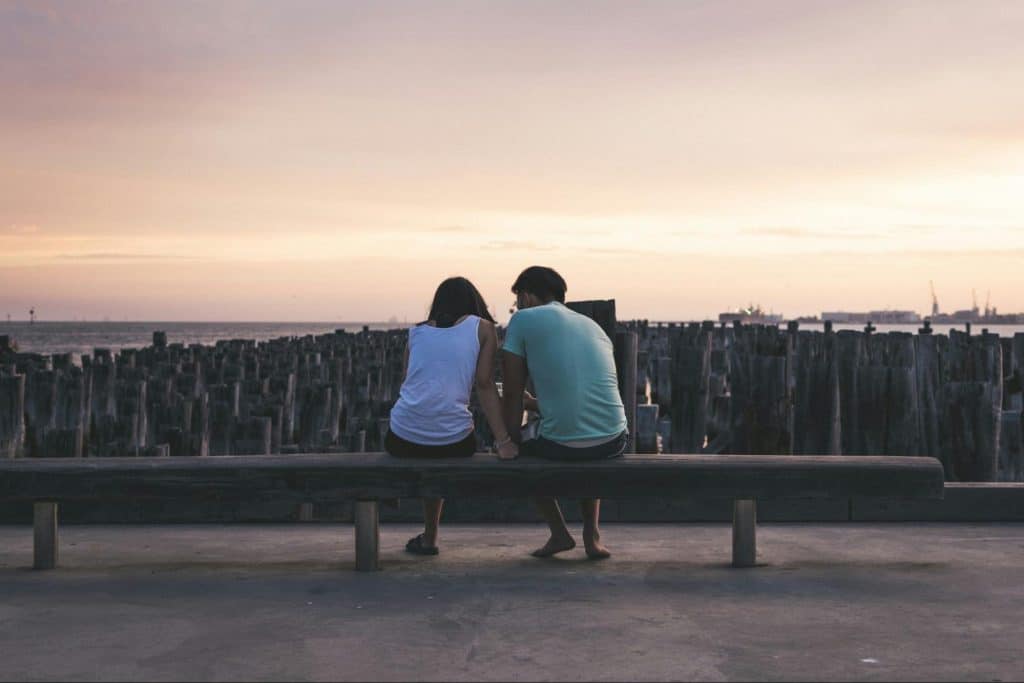 A man and woman sitting at the bench