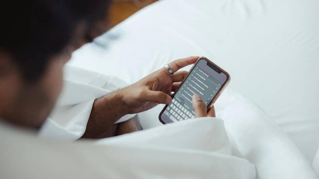 A person in bed using a smartphone.