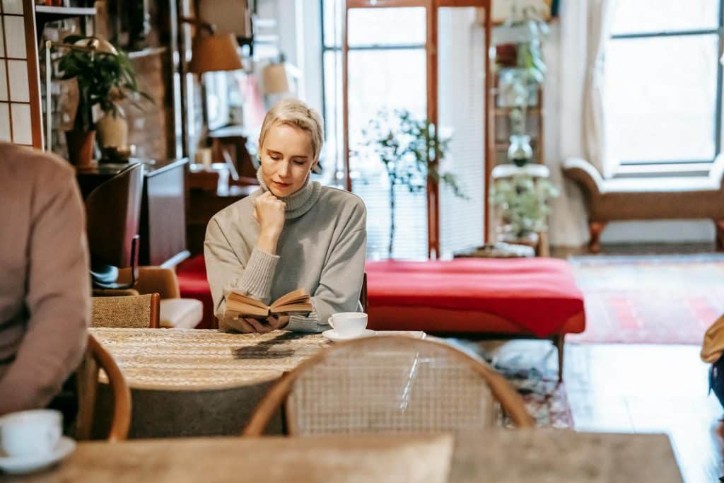 The woman is reading a book at home