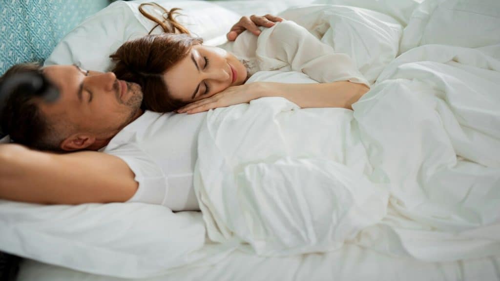 A couple sleeping together in bed