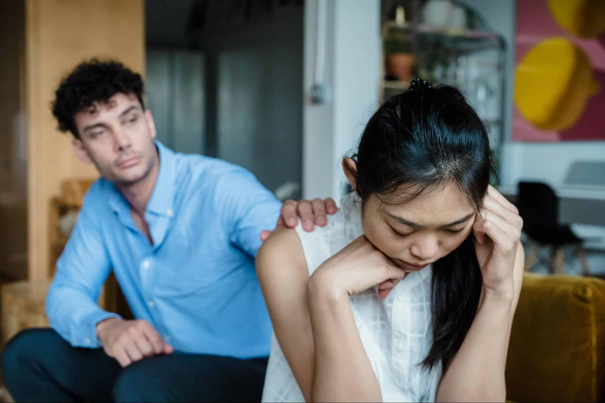 A man reaching for woman’s shoulder