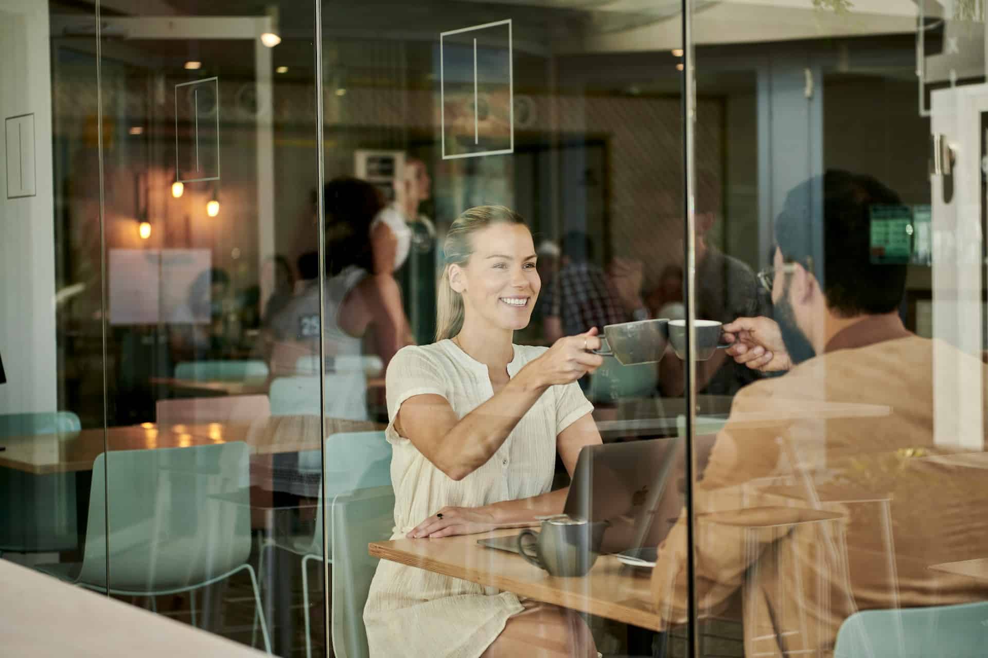 A woman in white shirt sitting in a café with a man