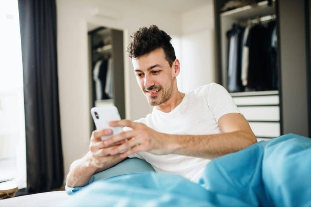 A man happily using a phone