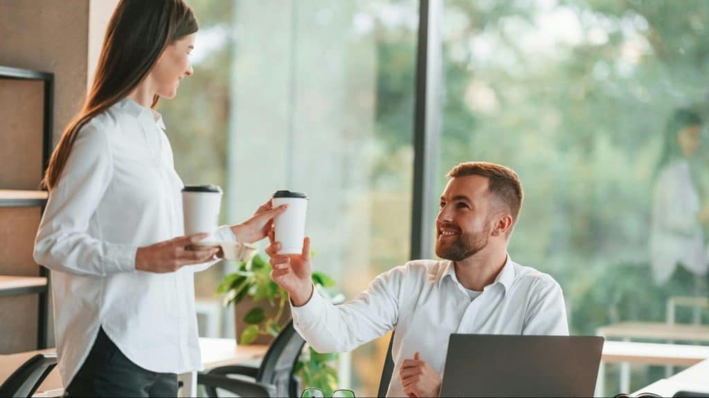 A woman giving man a coffee