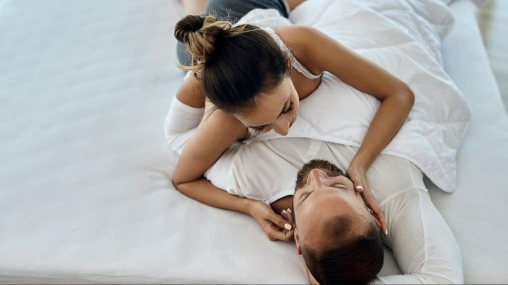 A man and woman at the bed being sweet