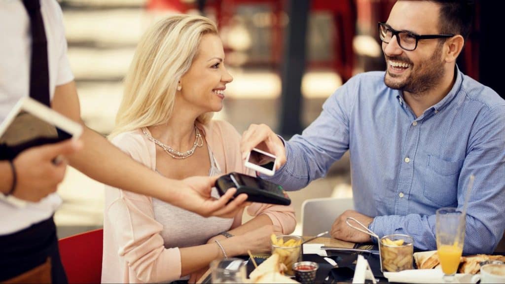 A woman observing a man’s action towards the staff of the restaurant