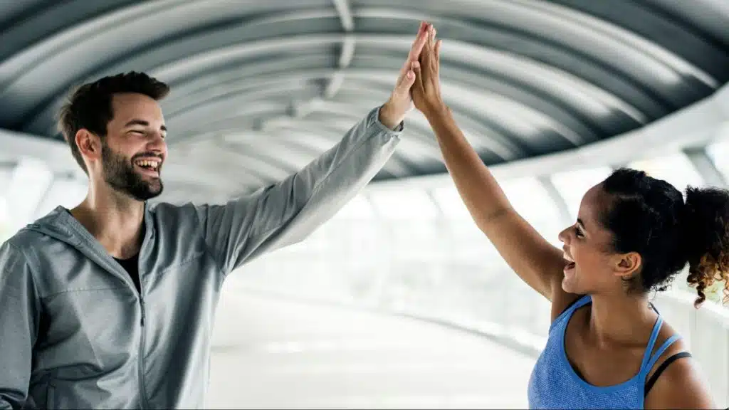 A man and woman doing a high-five as an appreciation for each other