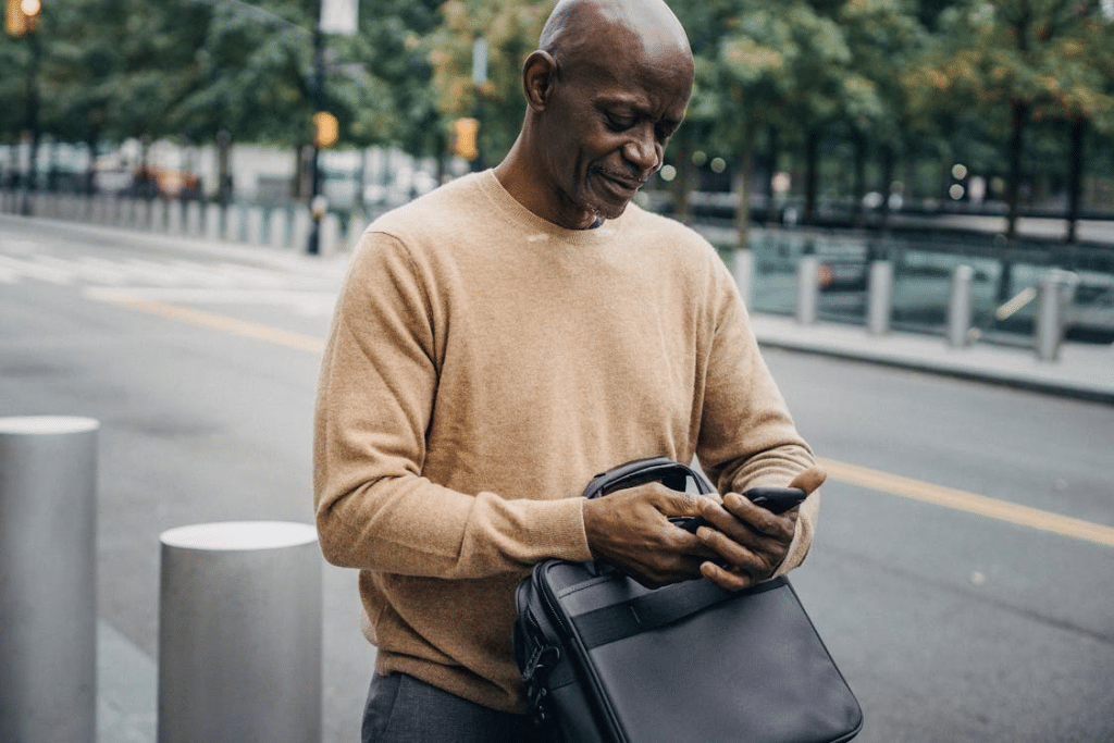 A man smiling while using his phone