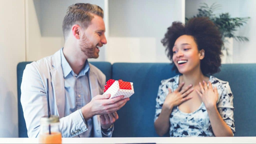 A man surprising a woman with a gift