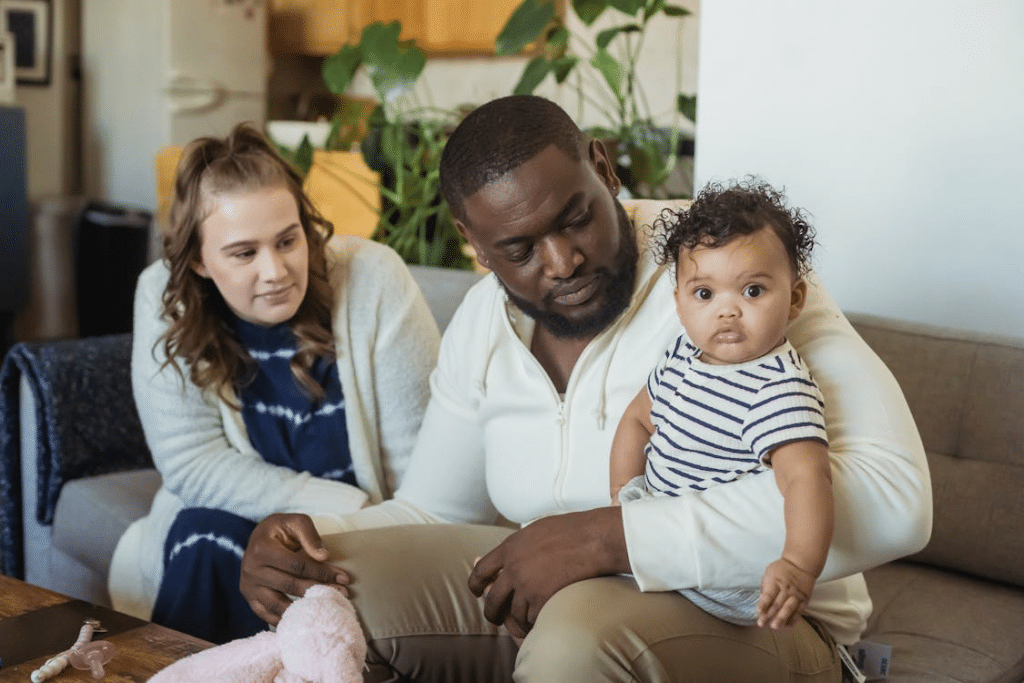 Multiethnic mother looking admirably at father with cute baby