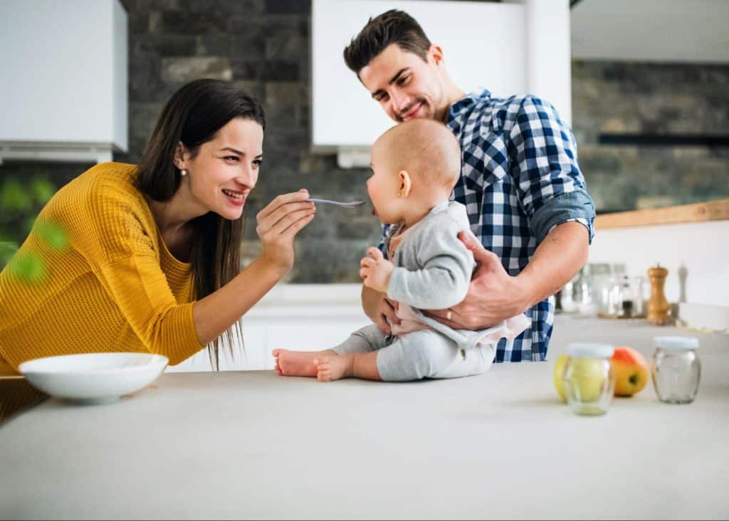 A man and woman feeding their child