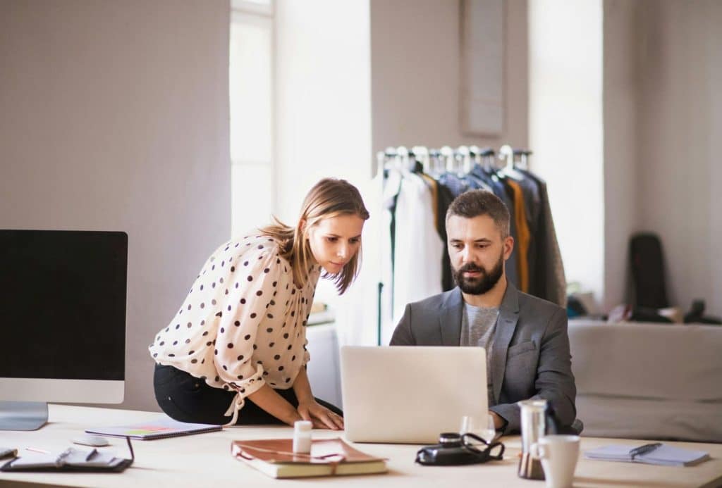 A man and woman looking at the laptop