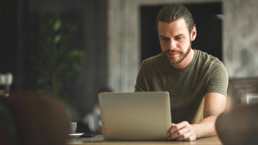 A man working on a laptop at a table.