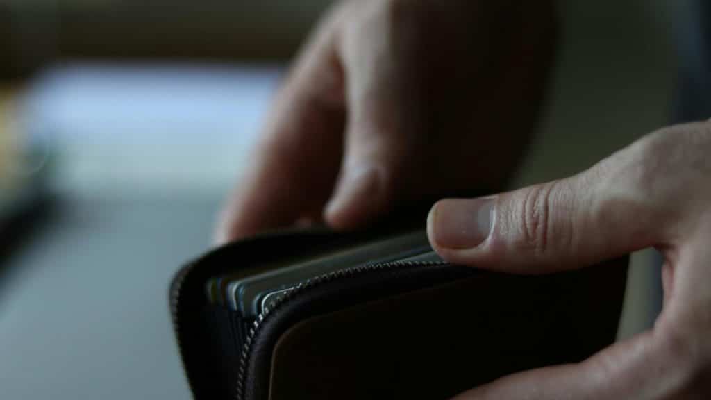 A person opening a wallet filled with cards.