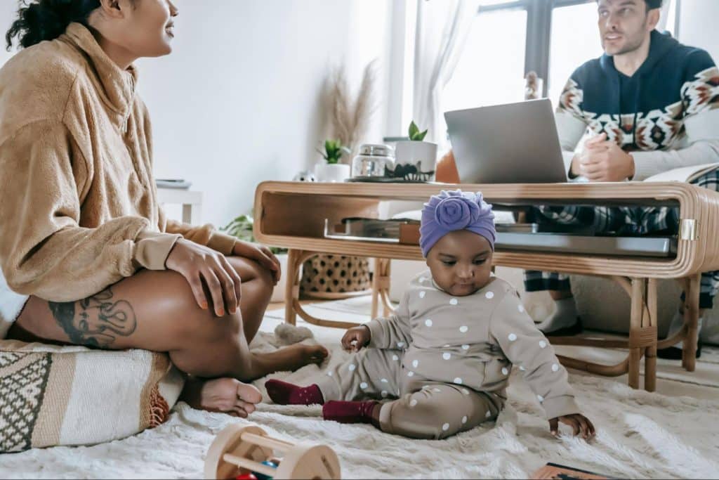 A man and woman at home with their child 