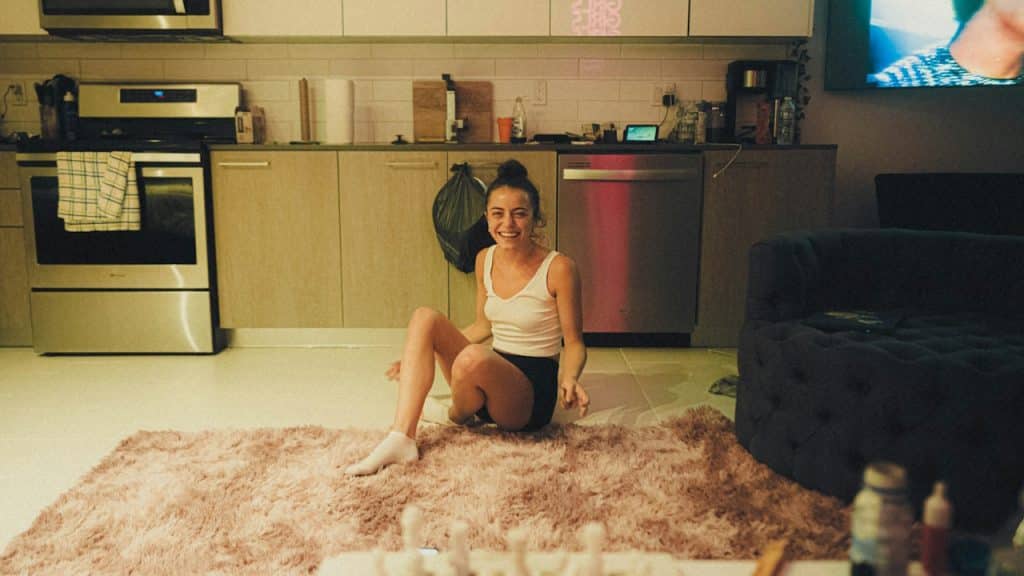 A woman sitting on a kitchen floor.