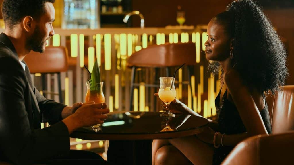A couple enjoying cocktails together at a stylish bar.
