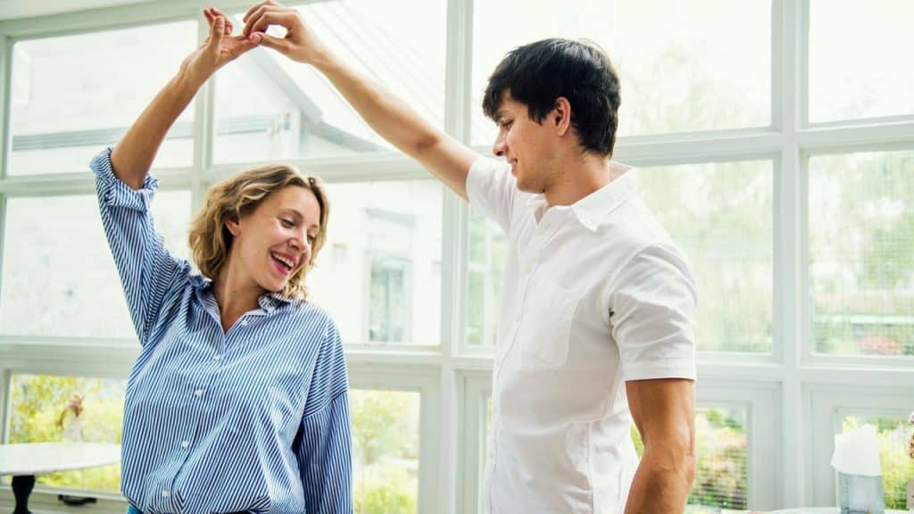 A couple dancing together indoors in a bright room.