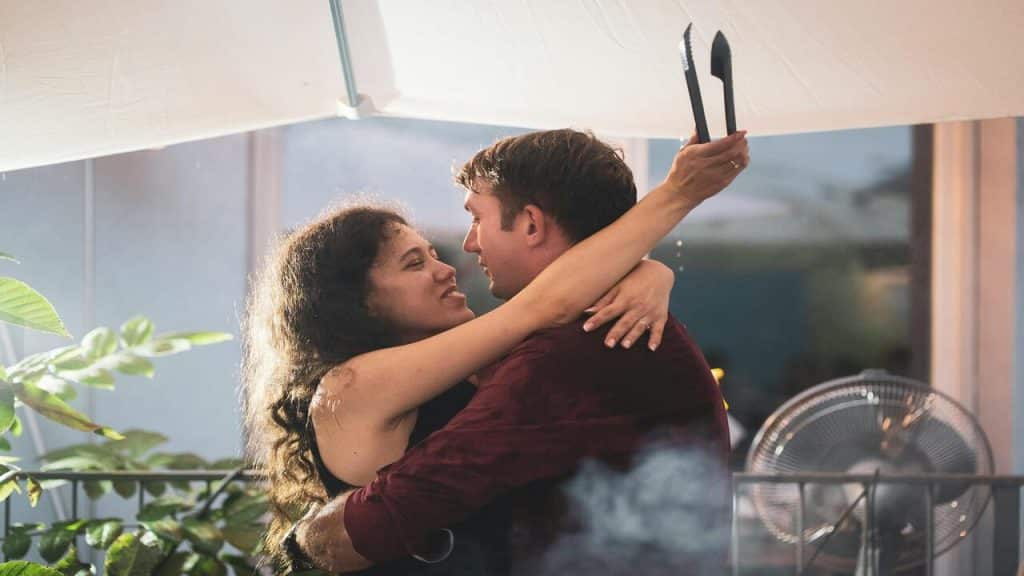 A couple hugging during a barbecue party