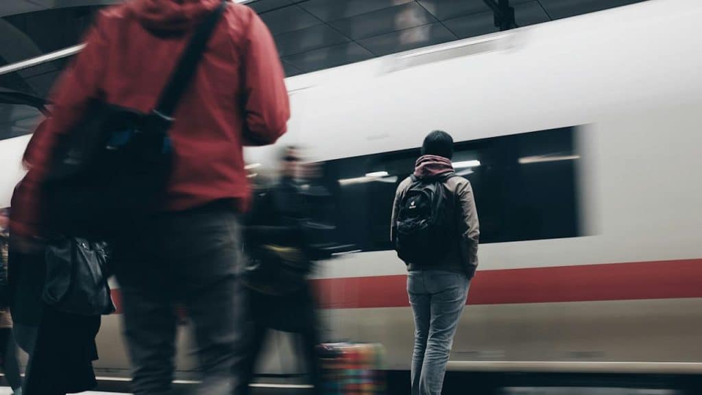 Man standing near a moving train.