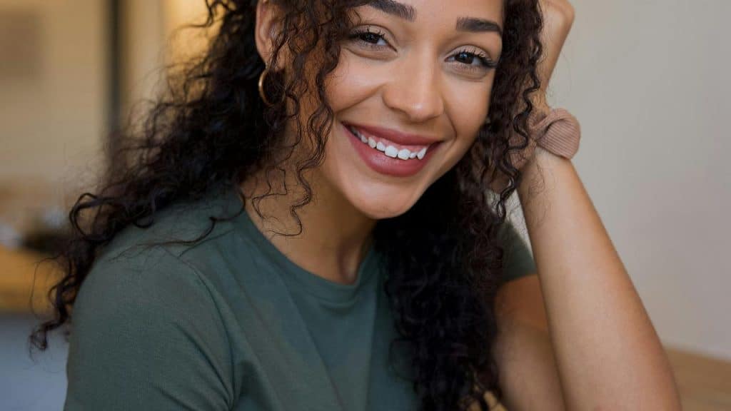 A smiling woman with curly hair looking at the camera.