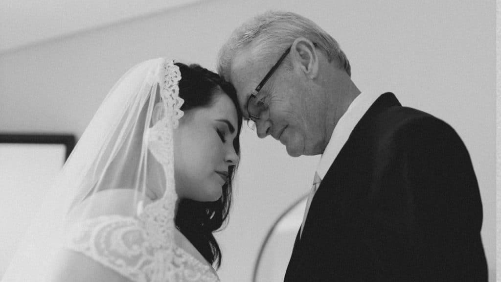A man and a woman touching heads while standing.