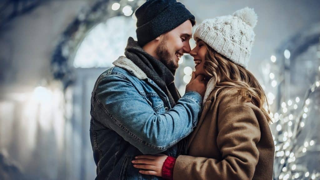 A young couple about to kiss outdoors.