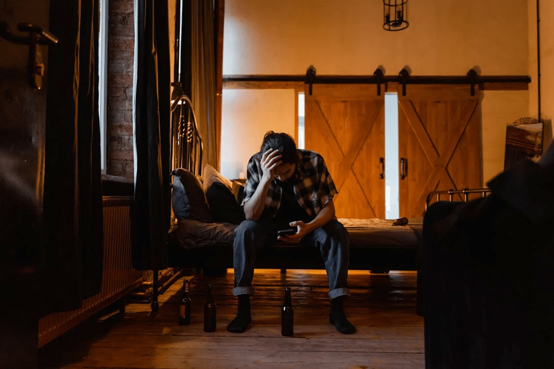 A sad man sitting on the bed