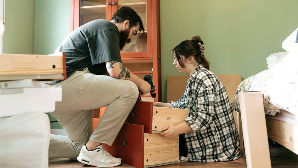 A couple is assembling furniture in their new home.