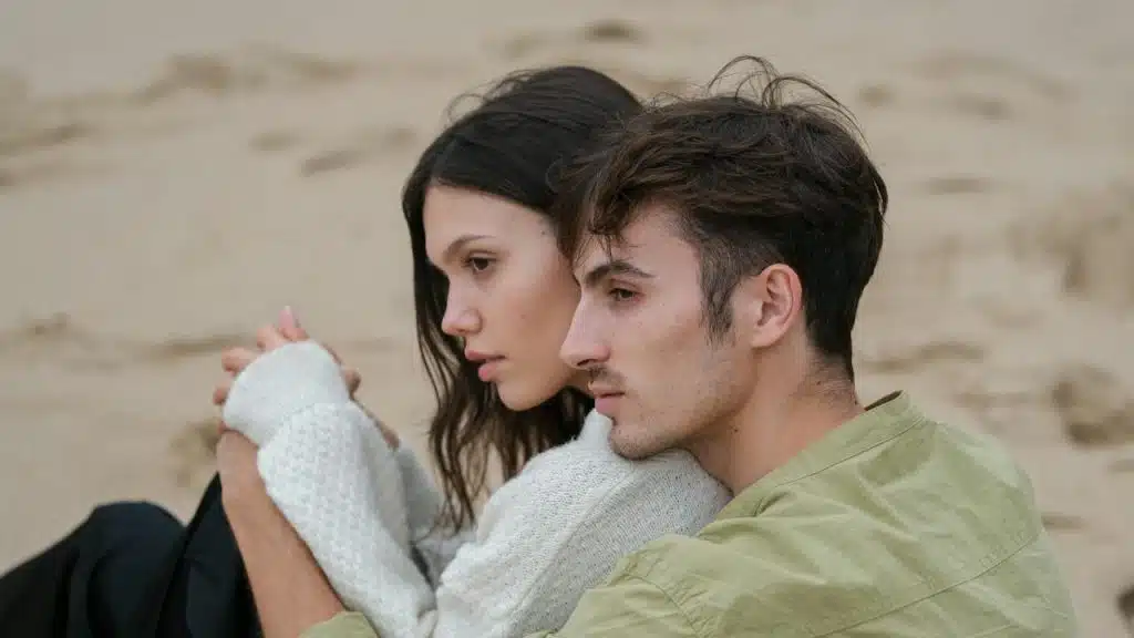 A man holding a woman from behind while sitting.