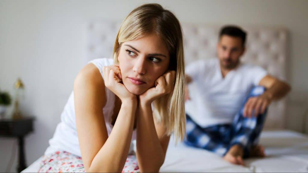 A man and woman at the bed but not talking to each other