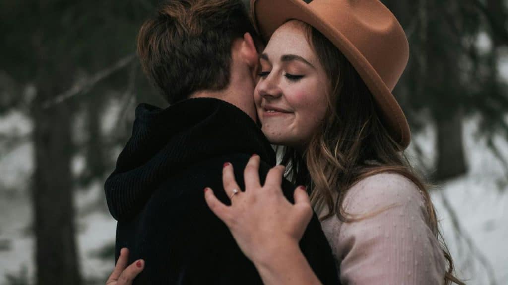 A couple embracing closely outdoors, sharing a tender moment.