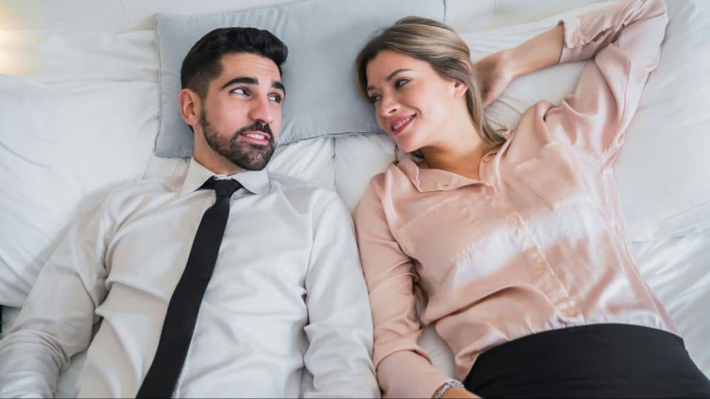 A man and woman at the bed