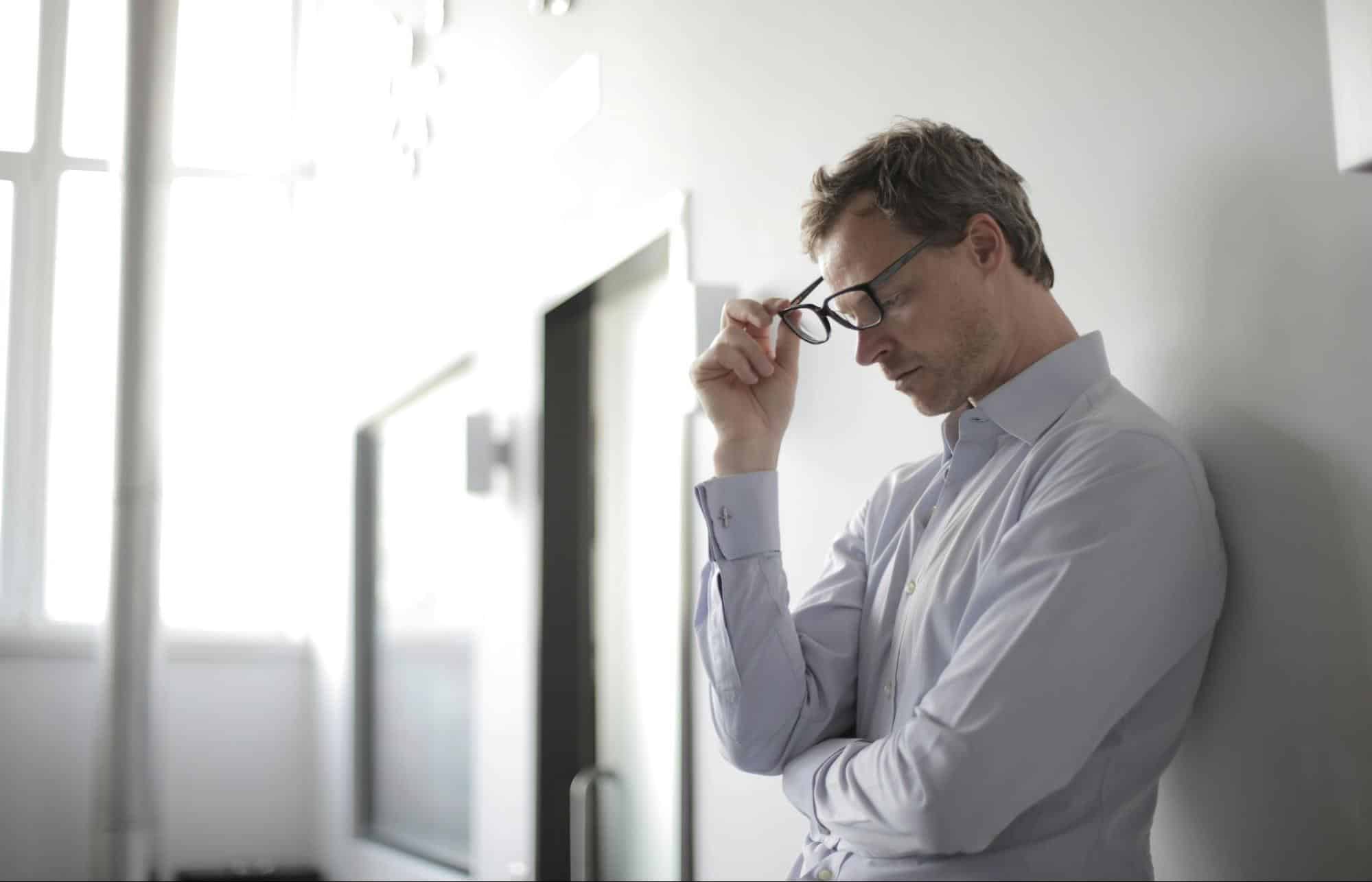 A man holding his glasses