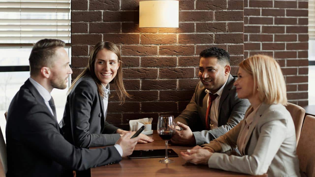 A group of four colleagues talking at a table.