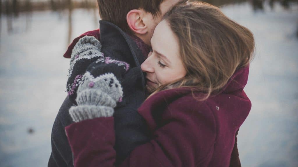 A man and woman hugging each other.