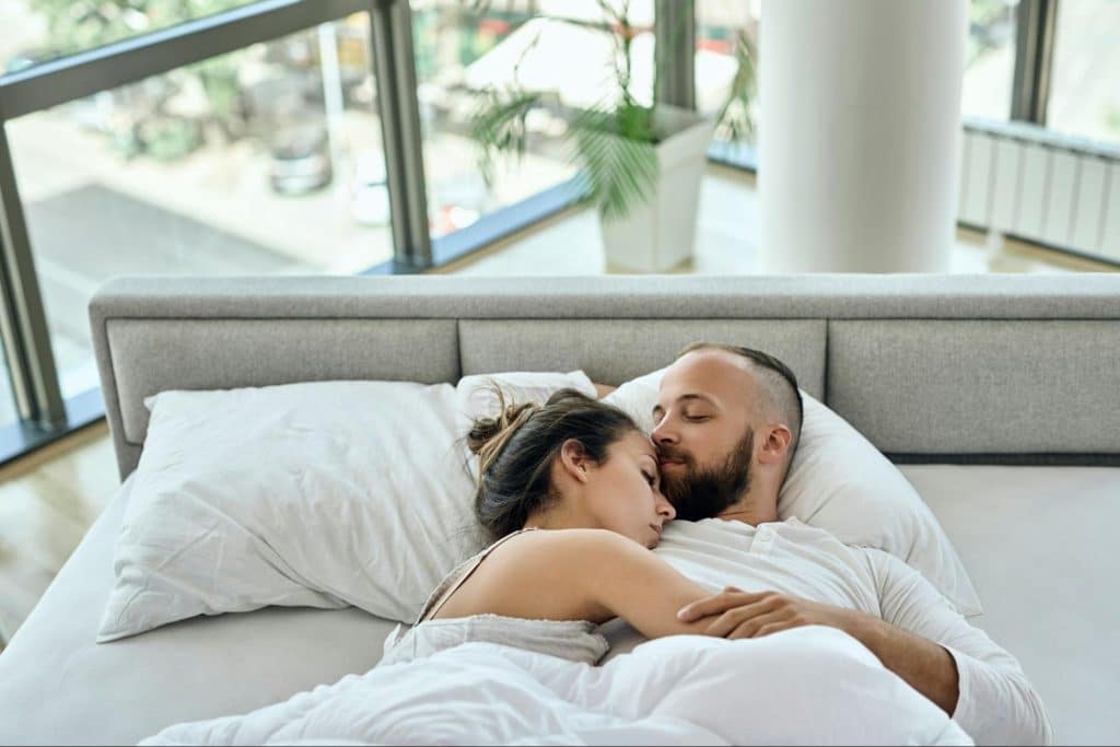 A man and woman at the bed