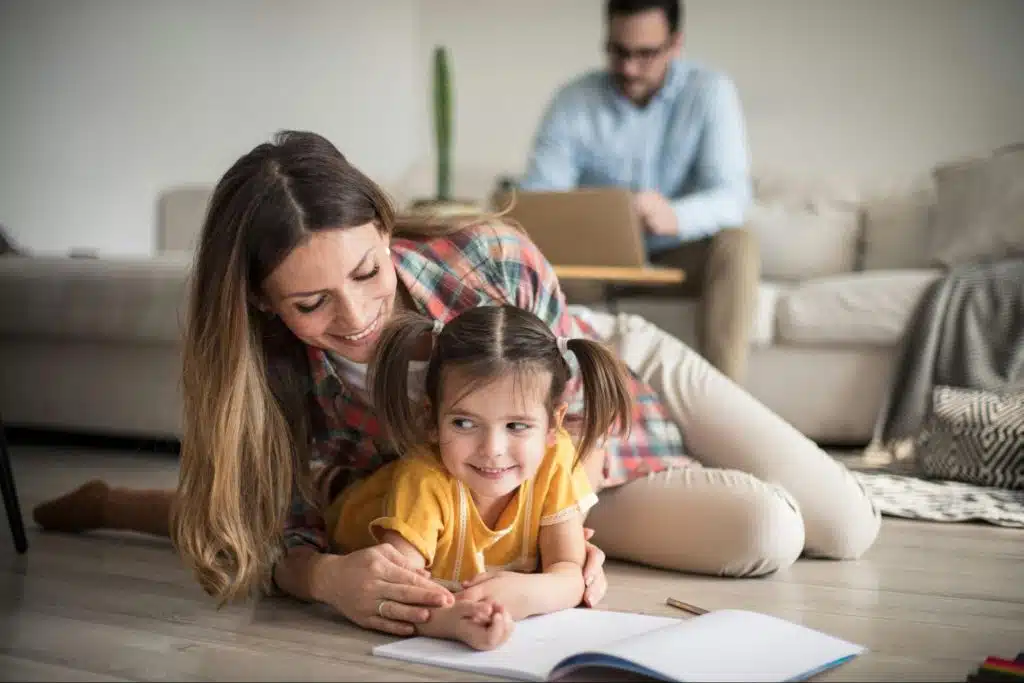 A woman taking care of the child while a man working