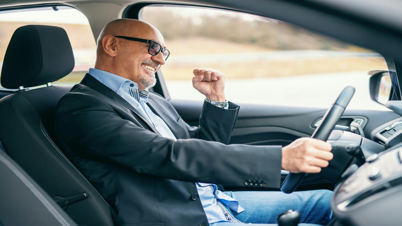 A man smiling while driving