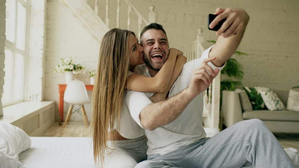 A couple taking a selfie in bed together