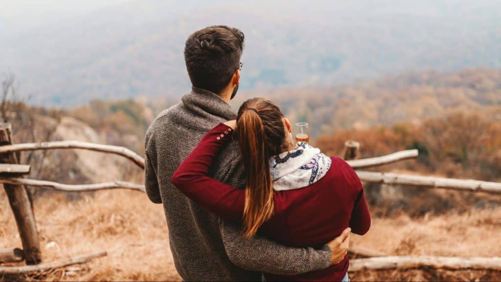 A man embracing a woman while looking at the view