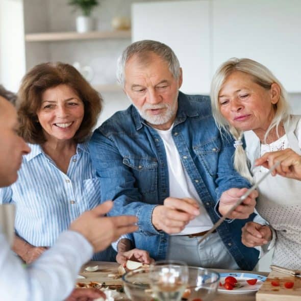 Older friends preparing a meal together