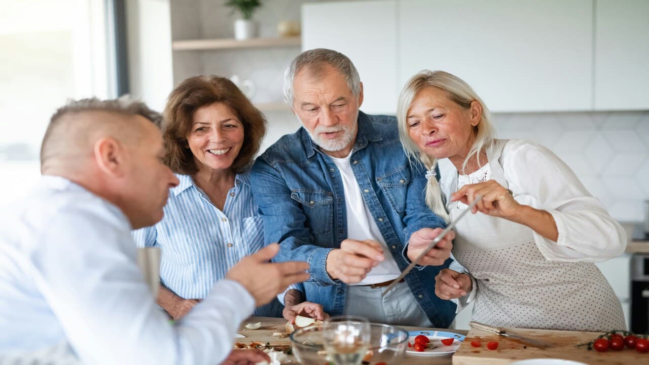Older friends preparing a meal together