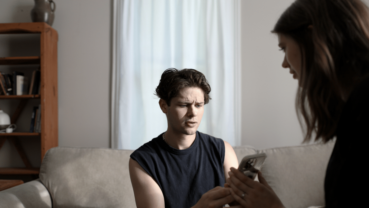 A man looking at his girlfriend’s phone