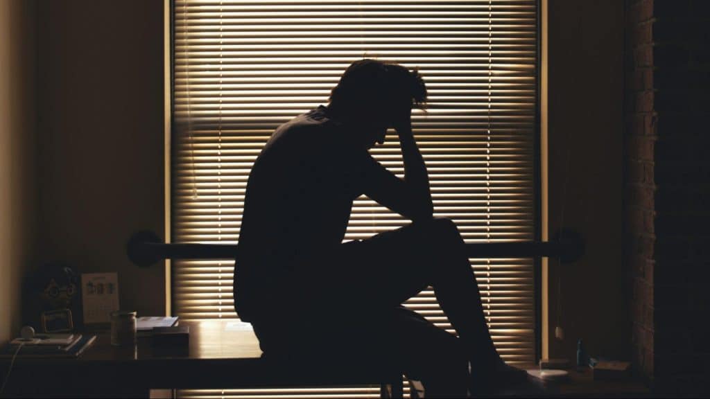 A man sitting and holding his head